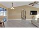 Open concept living room featuring tile floors, neutral paint, fan, and access to outdoor seating area at 295 Porto Alegre St, Punta Gorda, FL 33983