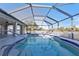 The home's screened-in pool and pool deck shows the surrounding greenery, and part of the lanai at 295 Porto Alegre St, Punta Gorda, FL 33983