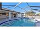 A screened-in pool shows surrounding greenery, part of the home's lanai, and blue skies at 295 Porto Alegre St, Punta Gorda, FL 33983