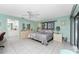 Spacious bedroom features tile floors, ceiling fan, light-green walls, and access to the ensuite bathroom at 349 Grenada St, Port Charlotte, FL 33948