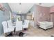 Dining area featuring a glass table, white upholstered chairs, and neutral tile flooring at 349 Grenada St, Port Charlotte, FL 33948