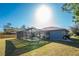 Backyard view of a screened-in pool and spacious lawn, perfect for outdoor enjoyment at 349 Grenada St, Port Charlotte, FL 33948