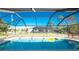 Screened pool featuring clear blue water, floatation toys, and backyard views at 349 Grenada St, Port Charlotte, FL 33948