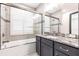 Modern bathroom featuring a granite countertop, sleek gray cabinetry, and stylish tiled shower and tub at 3612 Licata Ct, Punta Gorda, FL 33950