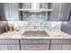 Close-up of kitchen features, including granite countertops, tile backsplash, and stainless steel stove top and hood at 3612 Licata Ct, Punta Gorda, FL 33950