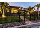 Night view of a beautiful home with a screened lanai, illuminated by landscape lighting at 3612 Licata Ct, Punta Gorda, FL 33950