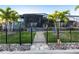 Beautiful home with a screened lanai, black fence, and lush landscaping with palm trees at 3612 Licata Ct, Punta Gorda, FL 33950