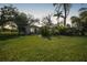 Charming home showcasing a lush front yard with mature trees and tropical landscaping at 3615 Sleepy Hollow Ln, Punta Gorda, FL 33950