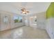 Bright living room with tile floors, ceiling fan and natural light with view to the outdoors through a large window at 3615 Sleepy Hollow Ln, Punta Gorda, FL 33950