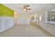 Bright living room with tile floors, ceiling fan and natural light with view to the outdoors through a large window and door at 3615 Sleepy Hollow Ln, Punta Gorda, FL 33950