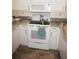 Close-up of white oven and granite countertops, complemented by white cabinets and stainless steel sink at 4000 Bal Harbor Blvd # 527, Punta Gorda, FL 33950