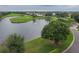 Beautiful aerial view of the property, featuring a serene lake, lush landscaping, and a well-manicured golf course at 10256 Shadow Run Ct, Punta Gorda, FL 33955