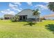 Landscaped backyard with green grass and the home's screened in lanai at 10256 Shadow Run Ct, Punta Gorda, FL 33955