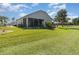 Well-maintained backyard with lush green grass and a screened-in lanai at 10256 Shadow Run Ct, Punta Gorda, FL 33955