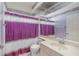 Cozy bathroom featuring a single sink vanity and a bathtub with a purple shower curtain at 10256 Shadow Run Ct, Punta Gorda, FL 33955
