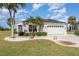 Beautiful home with a manicured lawn, palm trees, and a paver driveway at 10256 Shadow Run Ct, Punta Gorda, FL 33955
