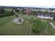 Scenic aerial view of a lush golf course with a clubhouse, golf carts, and mature trees at 10256 Shadow Run Ct, Punta Gorda, FL 33955