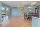 Open living space featuring hardwood floors, ceiling fan, and adjacent dining area and lanai access at 10256 Shadow Run Ct, Punta Gorda, FL 33955