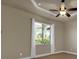 Bedroom with tray ceilings, ceiling fan, natural lighting, and a large window with view at 1139 Harbour Glen Pl, Punta Gorda, FL 33983