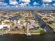Aerial view of a waterfront property featuring a private boat dock, solar panels, screened-in lanai, and canal access for boating at 1217 Bobwhite Court, Punta Gorda, FL 33950