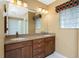 Bathroom featuring double sinks, ample counter space, and a glass block window at 1217 Bobwhite Court, Punta Gorda, FL 33950