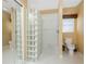 Bathroom with a walk-in shower featuring glass block, a white toilet, and tile flooring at 1217 Bobwhite Court, Punta Gorda, FL 33950