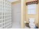 Bathroom with a glass block walk-in shower, white toilet, and tile flooring at 1217 Bobwhite Court, Punta Gorda, FL 33950