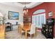 Dining room featuring a red accent wall, elegant light fixture, and an elegant china cabinet at 1217 Bobwhite Court, Punta Gorda, FL 33950