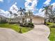 Charming home featuring a tile roof, brick driveway, and beautifully manicured landscaping with palm trees at 1217 Bobwhite Court, Punta Gorda, FL 33950