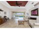 Bright living room with tile floors, fan, and sliding glass doors leading to a screened-in patio and pool at 1217 Bobwhite Court, Punta Gorda, FL 33950