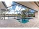 Stunning screened-in pool with a beautiful view of the canal and tropical landscaping at 1217 Bobwhite Court, Punta Gorda, FL 33950