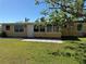 Back of house features an expansive backyard, a door, and large sliding glass doors at 21938 Catherine Ave, Port Charlotte, FL 33952