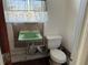 Bathroom features a charming vintage-style green sink and standard toilet at 21938 Catherine Ave, Port Charlotte, FL 33952