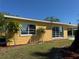 Side view of a yellow home featuring bright double-pane windows and lush landscaping at 21938 Catherine Ave, Port Charlotte, FL 33952