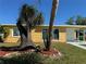 Charming exterior showcasing a well-maintained yard with palm trees and shrubs at 21938 Catherine Ave, Port Charlotte, FL 33952