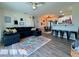 Open-concept living room, features modern decor, cozy seating, and breakfast bar with black stools at 21938 Catherine Ave, Port Charlotte, FL 33952