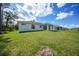 A spacious backyard featuring a well-maintained lawn and the home's rear facade at 23254 Stelling Ave, Port Charlotte, FL 33980