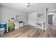 A comfortable bedroom features wood-look flooring, neutral paint, a ceiling fan, and natural light at 23254 Stelling Ave, Port Charlotte, FL 33980