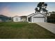 Single-story home with a well-manicured lawn, two-car garage, and modern architectural details at 23254 Stelling Ave, Port Charlotte, FL 33980