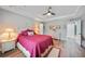 An inviting main bedroom features wood-look flooring, a ceiling fan, and wicker furniture at 23254 Stelling Ave, Port Charlotte, FL 33980