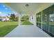 Covered patio with white floors and pillars overlooking the grassy lawn at 23254 Stelling Ave, Port Charlotte, FL 33980