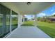 A covered patio with a view of the backyard and lush green lawn at 23254 Stelling Ave, Port Charlotte, FL 33980