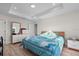 Bright bedroom featuring a tray ceiling, light wood floors, and soft natural light at 2405 Vancouver Ln, North Port, FL 34286