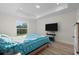 Bright bedroom featuring wood laminate flooring, a large TV, and tray ceiling at 2405 Vancouver Ln, North Port, FL 34286
