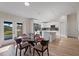 Open-concept dining area with a glass table set and adjacent modern kitchen at 2405 Vancouver Ln, North Port, FL 34286