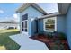 Back exterior view of home with landscaping, a window and side door at 2405 Vancouver Ln, North Port, FL 34286