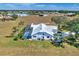 Stunning aerial view of a home with a pool, screened lanai, and beautifully landscaped grounds at 24344 Penhollow Ct, Punta Gorda, FL 33955