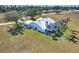 Spacious home with a screened lanai, pool, and lush green lawn surrounded by mature trees at 24344 Penhollow Ct, Punta Gorda, FL 33955