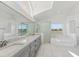 Well-lit bathroom with a double vanity, bathtub, and a separate glass-enclosed shower at 24344 Penhollow Ct, Punta Gorda, FL 33955