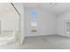Light-filled bedroom showcases soft carpeted floors and a glimpse into the ensuite bathroom at 24344 Penhollow Ct, Punta Gorda, FL 33955